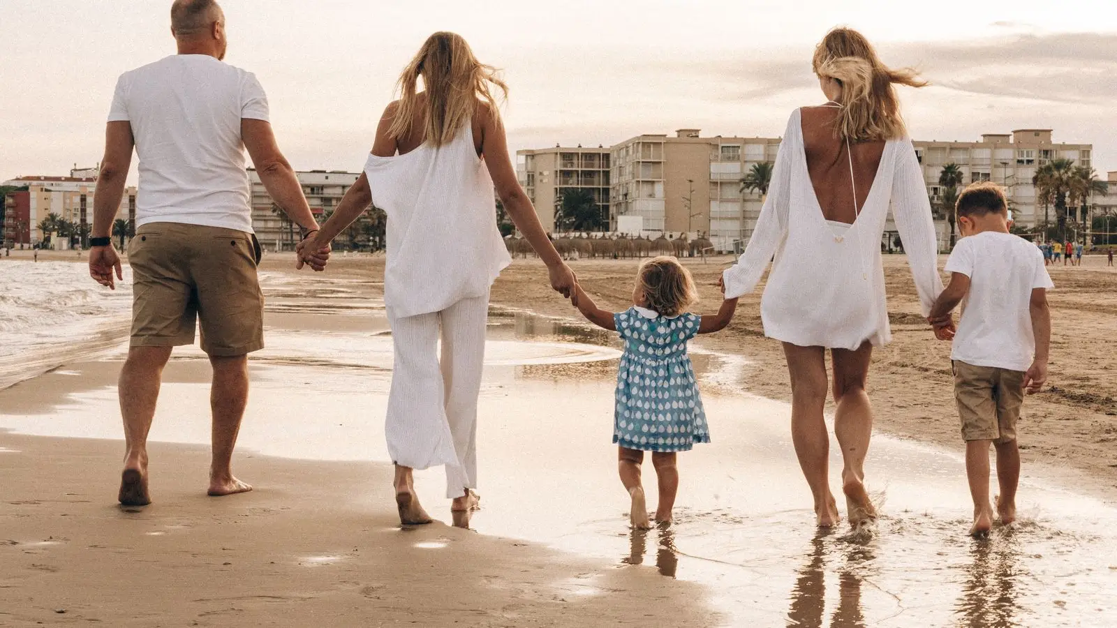 Familia jugando en la orilla de una playa de arena dorada en Orihuela Costa